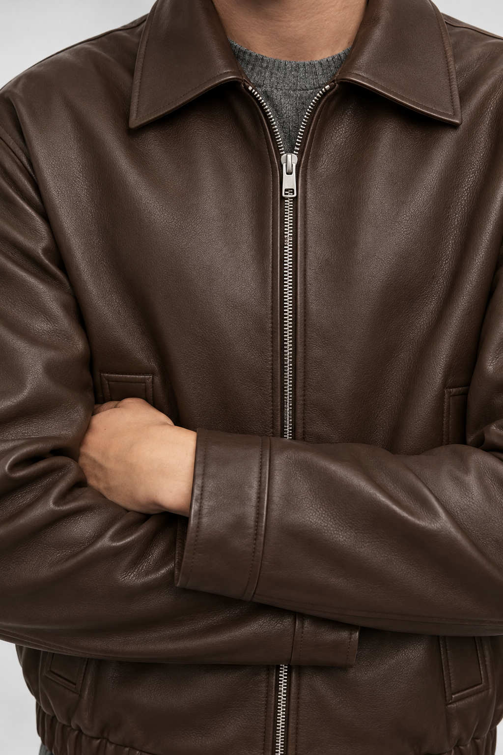 Close-up of espresso brown blouson collar, silver zip and textured finish